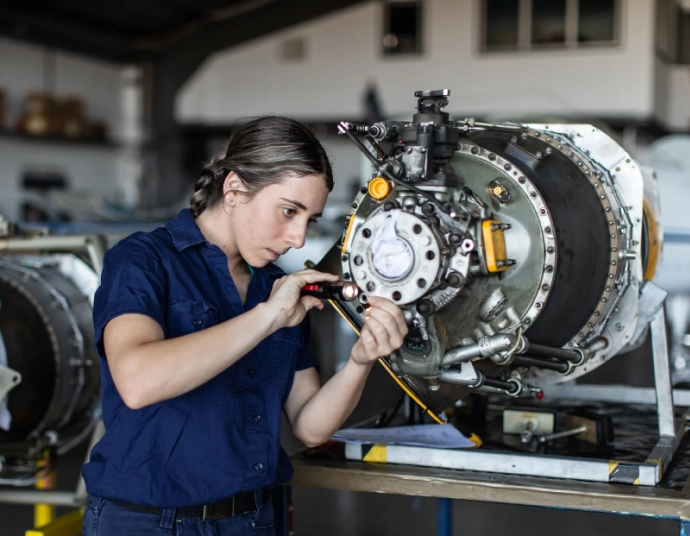 Aerospace quality inspector reviewing translated inspection documentation beside an aircraft structure