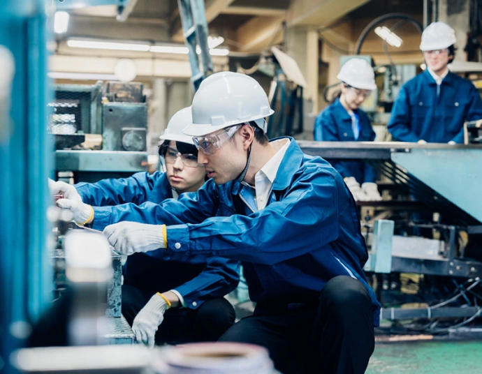 Machine operator consulting translated operating instructions at a workstation