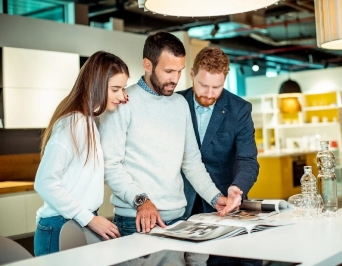 Multilingual industrial product catalog pages open on a design workstation