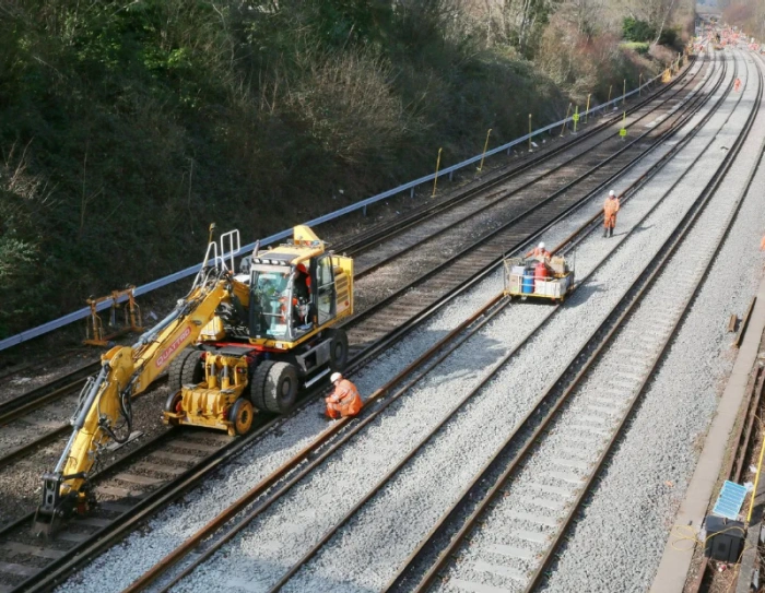Translator reviewing railcar maintenance documentation beside a light rail vehicle