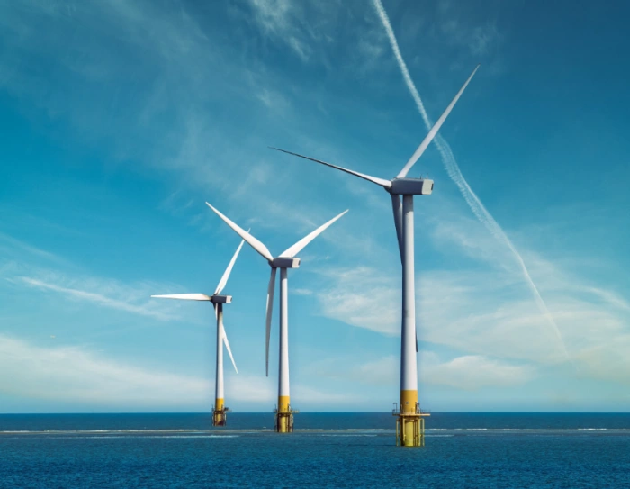 Wind technicians consulting a translated turbine service manual at a US wind farm
